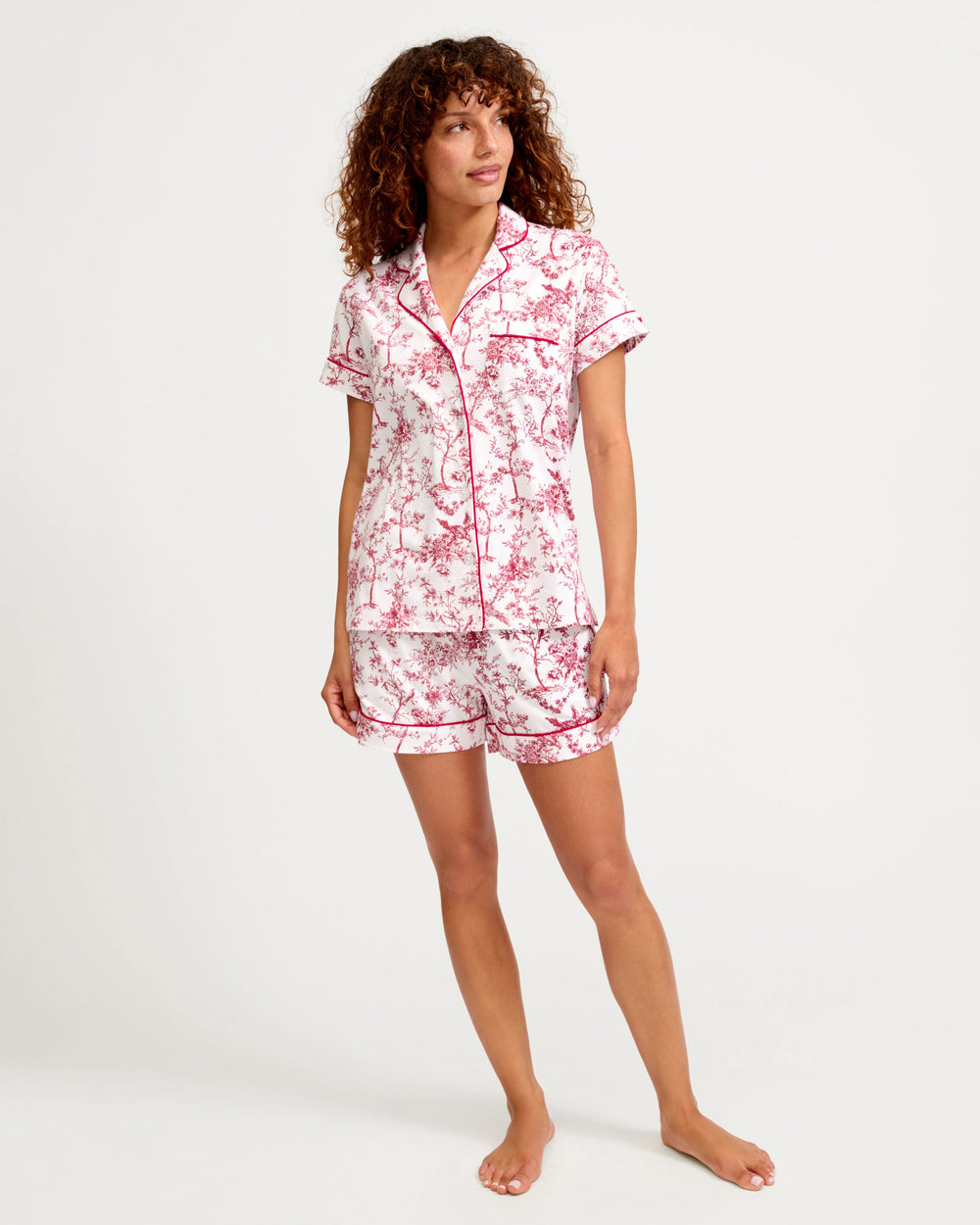 Woman wearing a floral pajama set on a white background