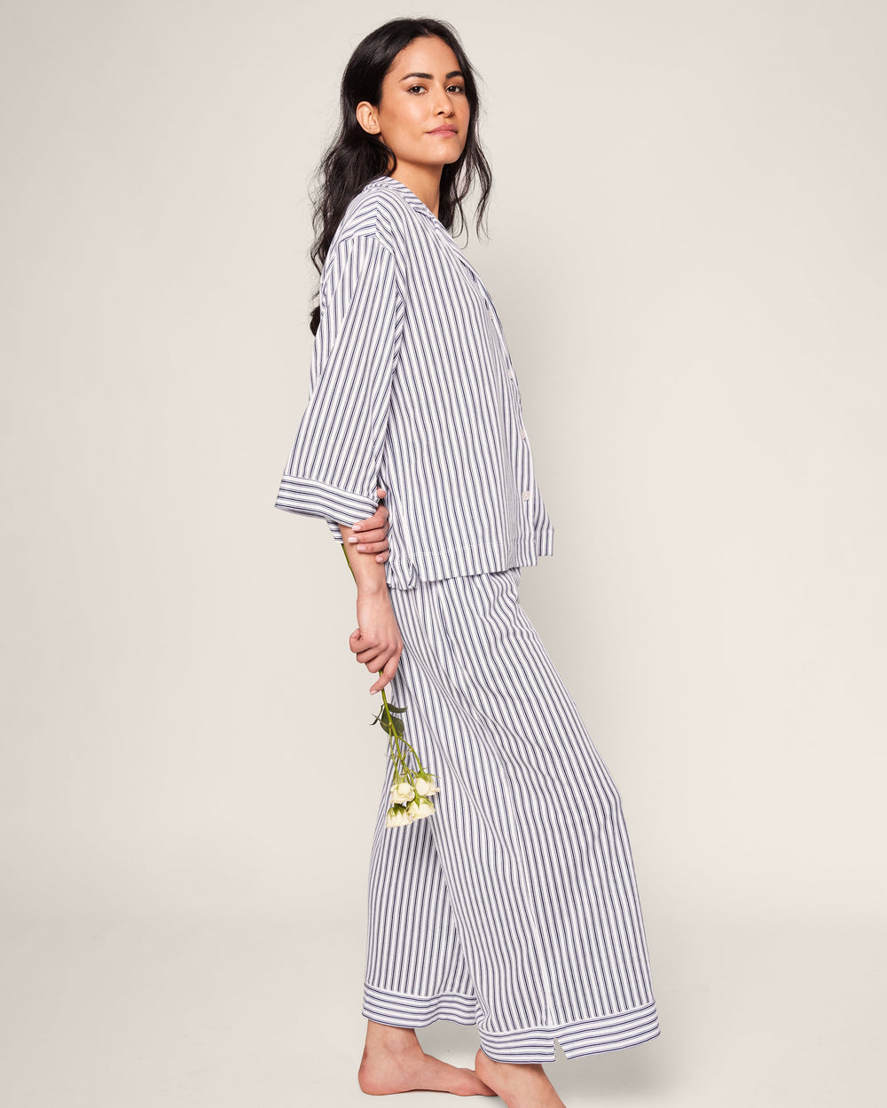 Woman wearing a blue and white striped outfit against a plain background