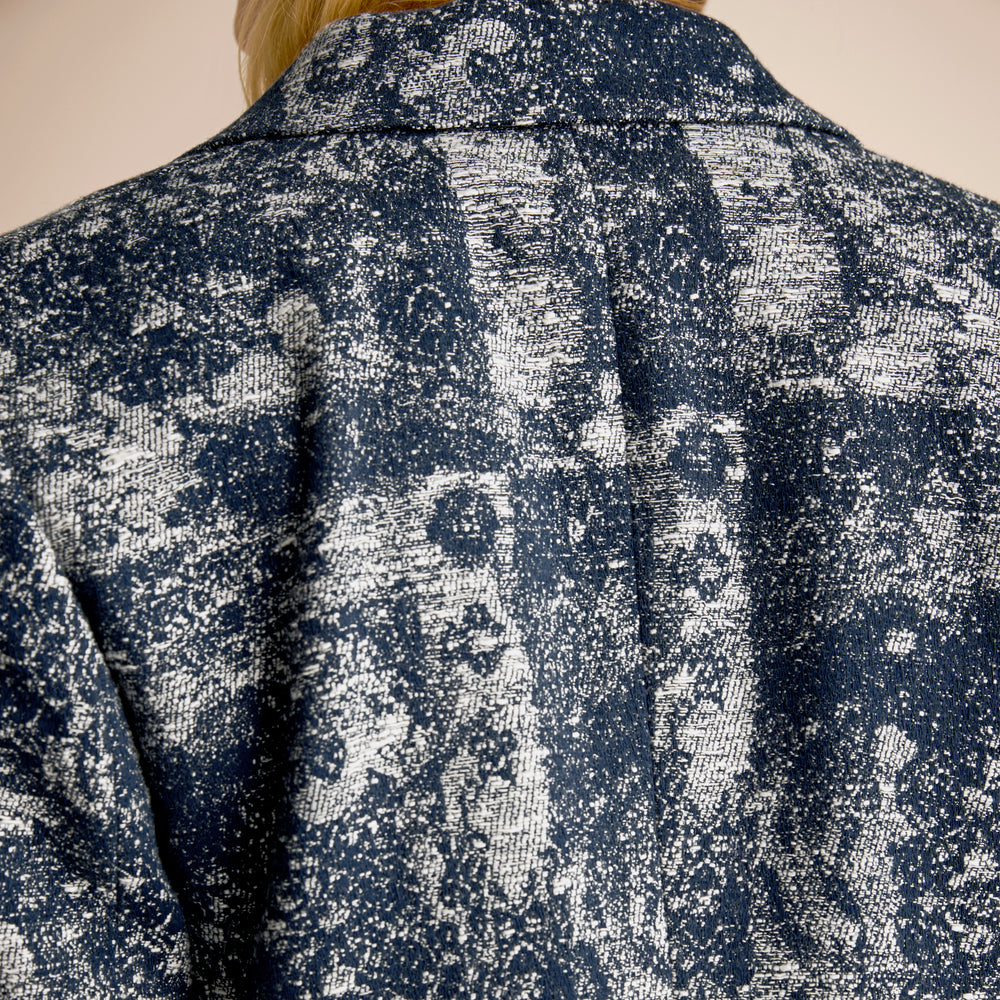 Woman wearing a blue floral suit on a beige background