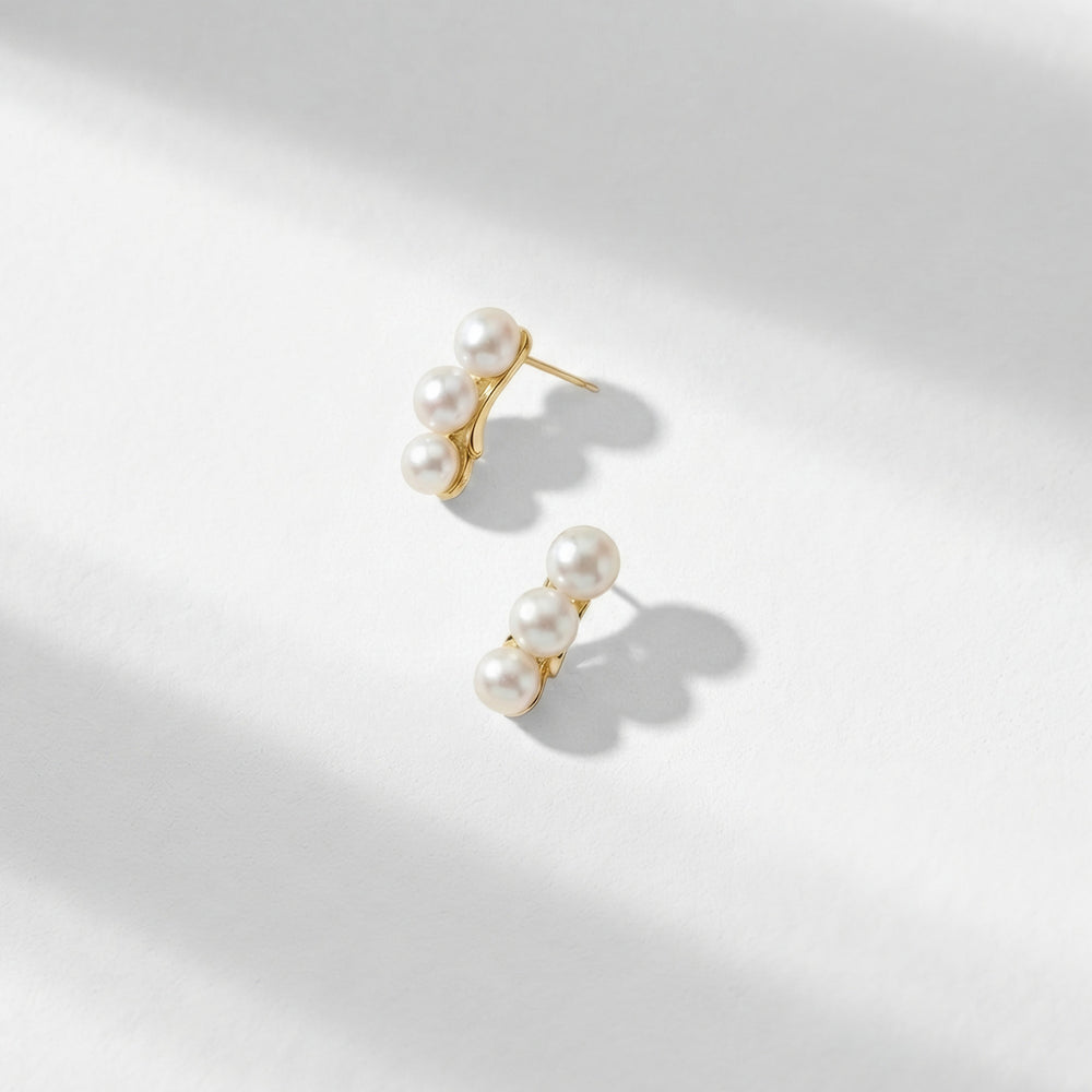 Packshots of the Sariah earrings that have three pearl balls and a gold back