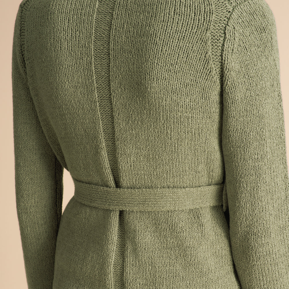 Green textured dress with a belt on a beige background