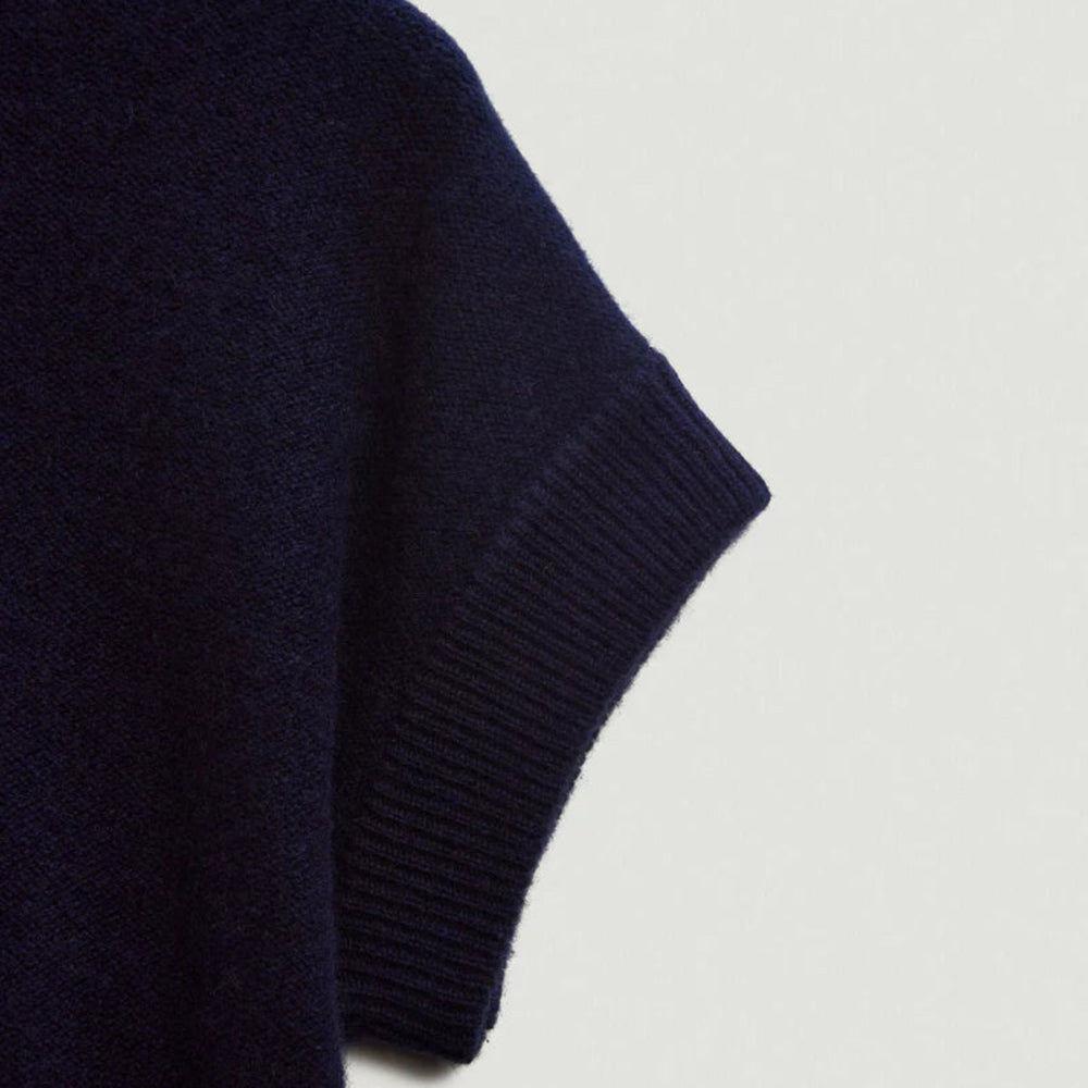 Navy blue sweater sleeve on a light gray background