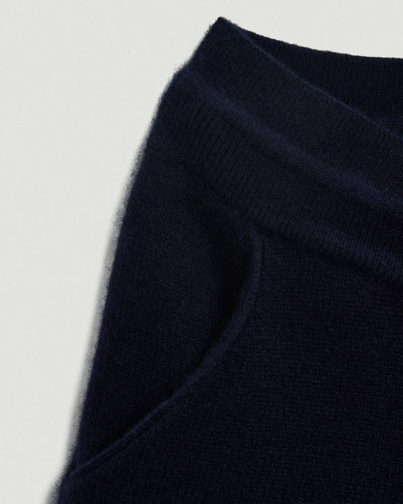 Close-up of a navy blue fabric texture on a light gray background.