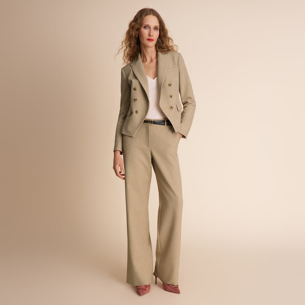 Woman wearing a beige suit on a beige background