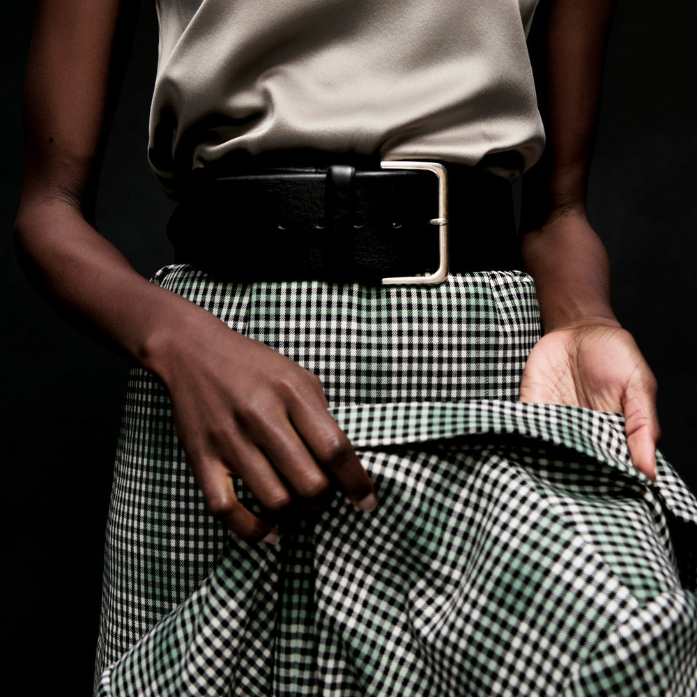 front image of a woman holding the dolly jacket in check plaid