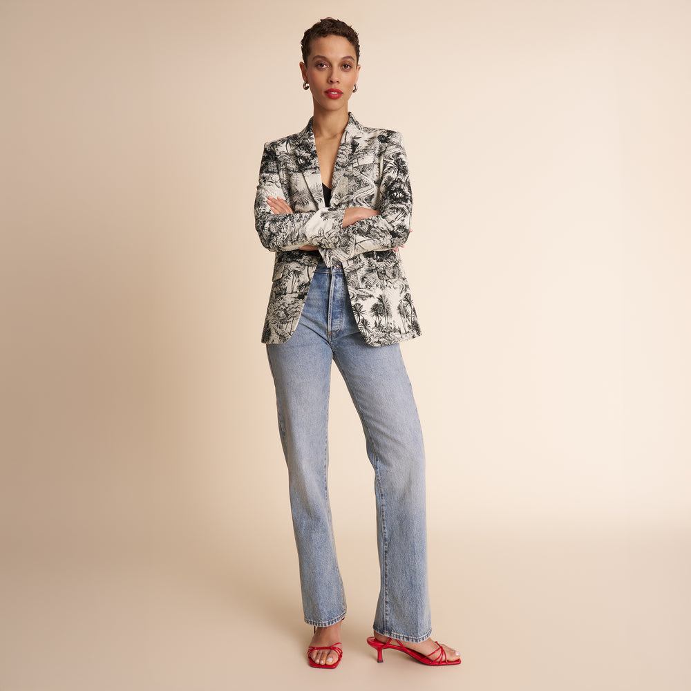 women in palm pattern blazer and blue jeans