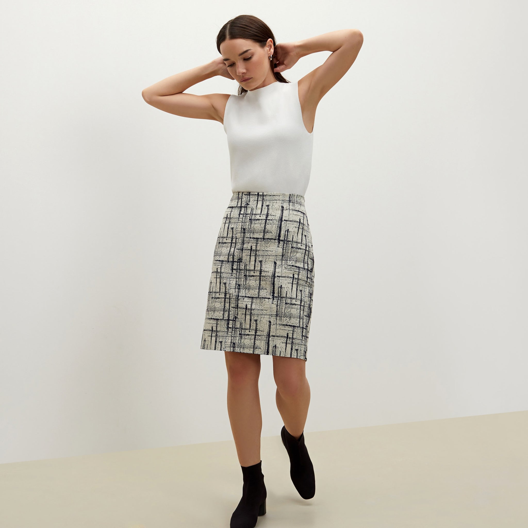 Side image of a woman standing wearing the Noho skirt in ivory / galaxy blue