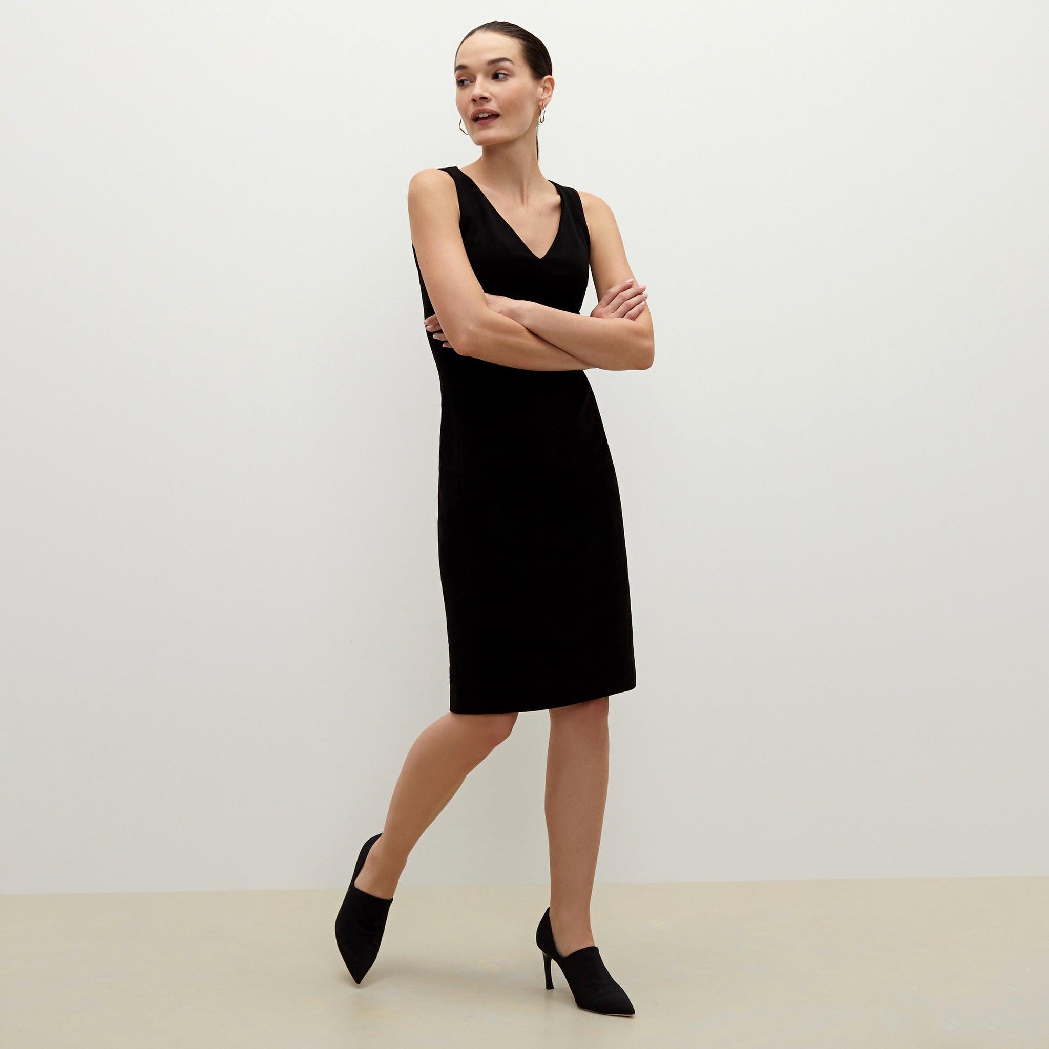 Side image of a woman standing wearing the Rachel dress in black