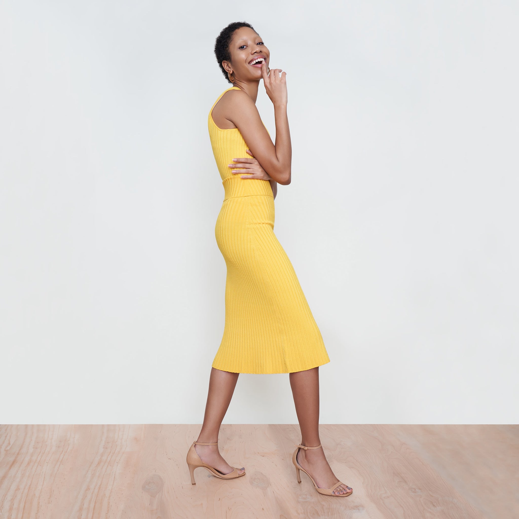 Side image of a woman standing wearing the York Skirt in Tuscan Yellow