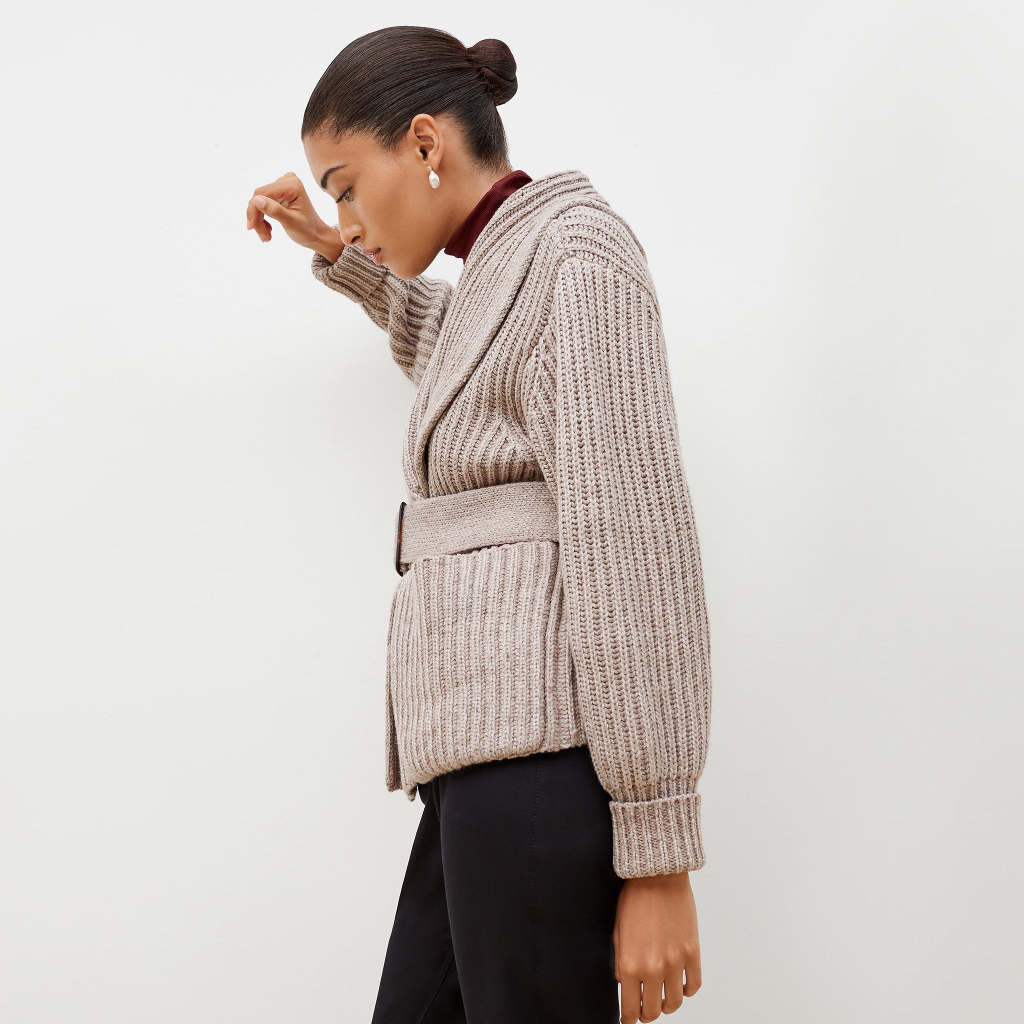 Side image of a woman standing wearing the Snyder Jacket—Lush Merino in Barley