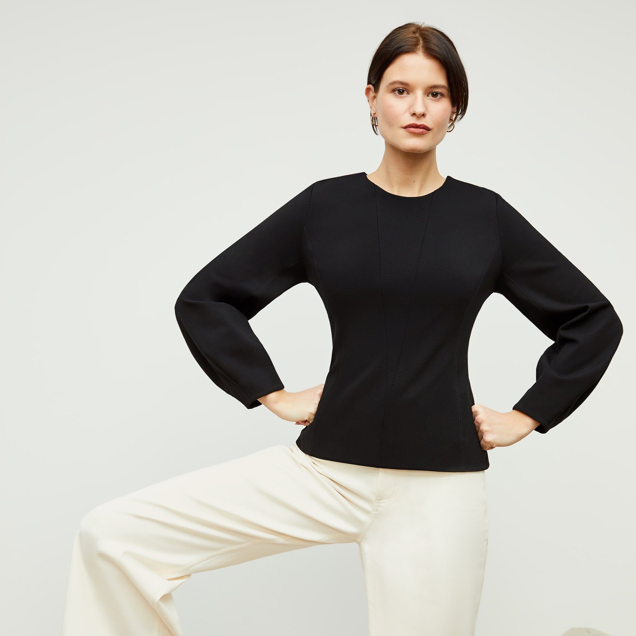 Front image of a woman standing wearing the rashida top in black 