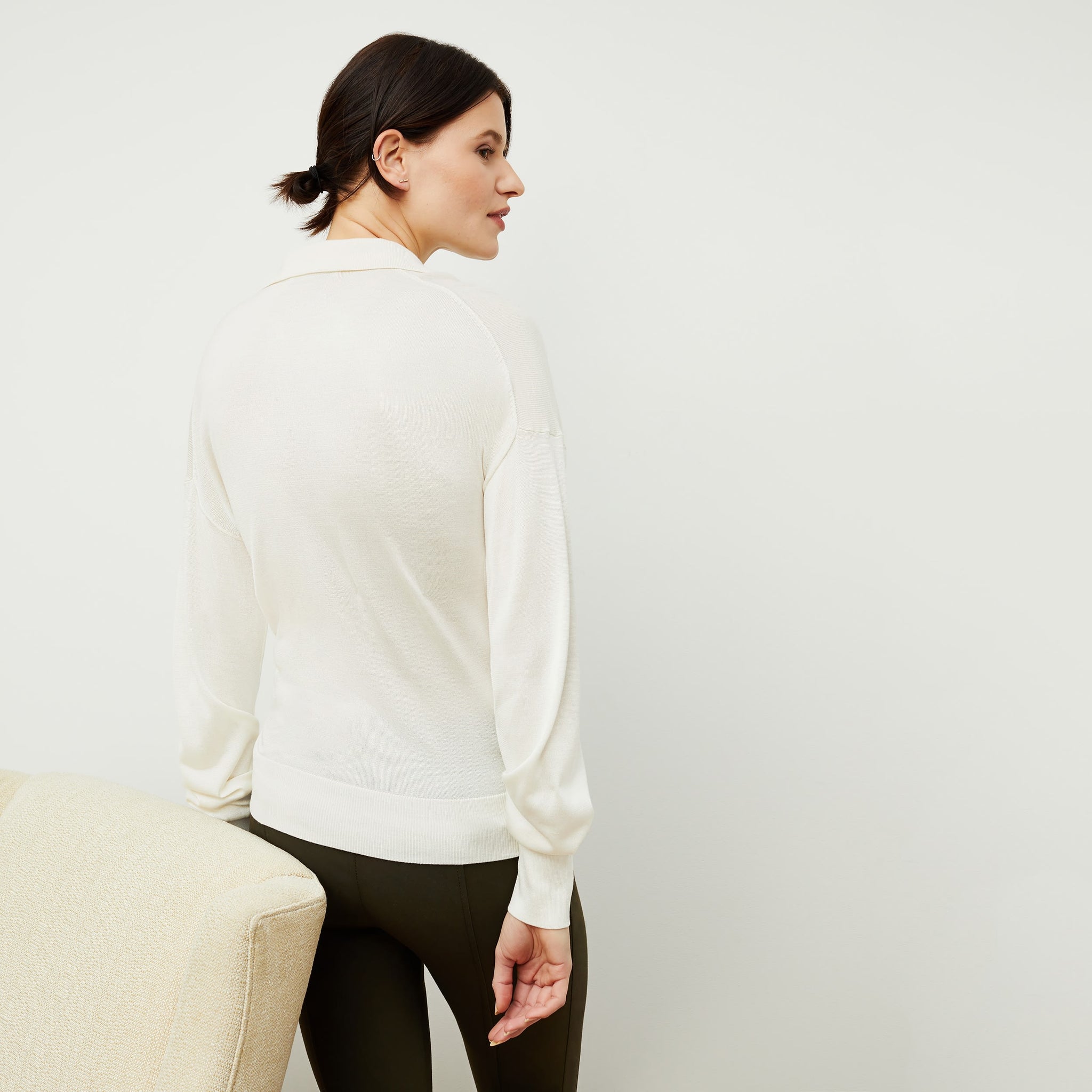 Back image of a woman standing wearing the leo top in cream