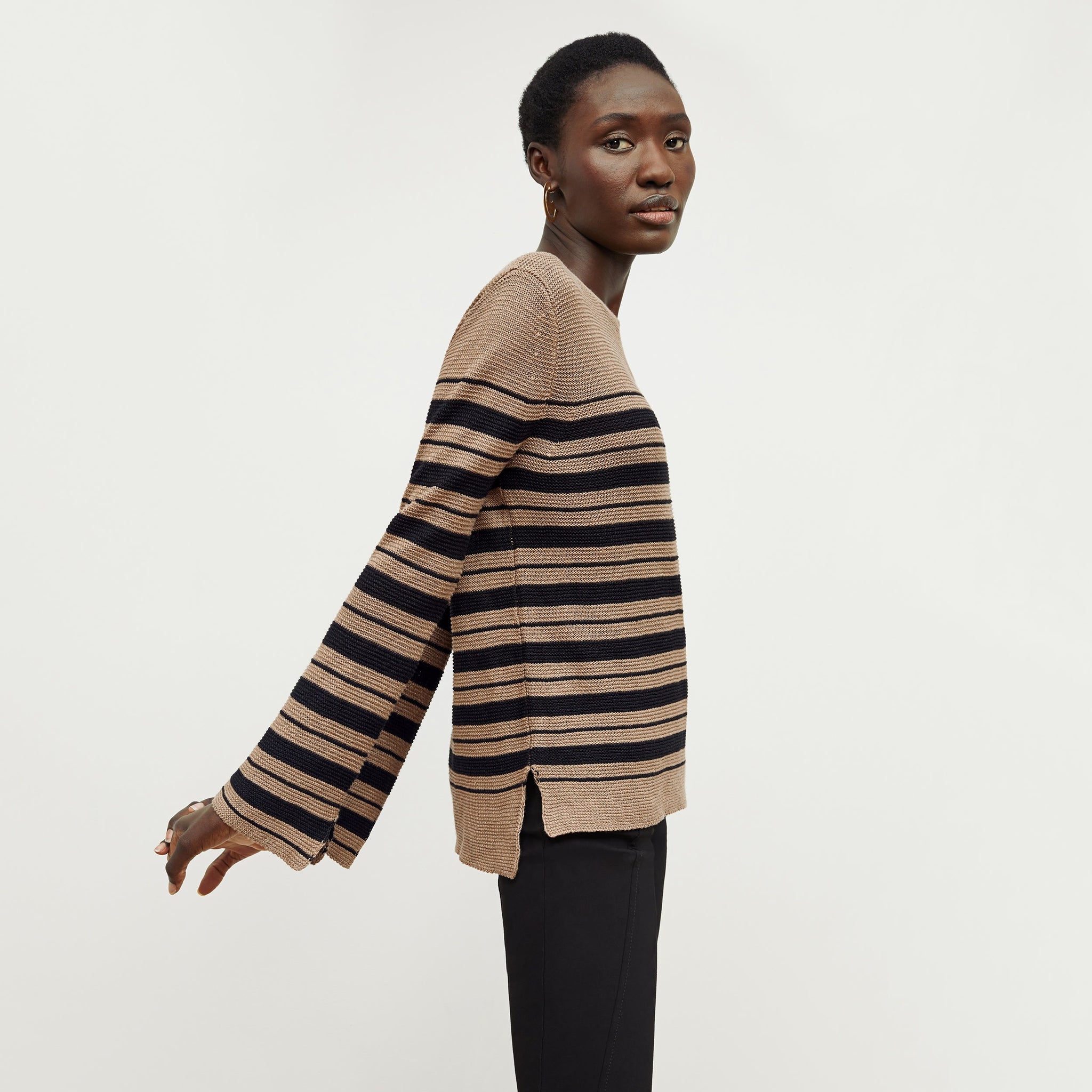 Side image of a woman standing wearing the Samara Sweater—Knit Linen in Oak / Black