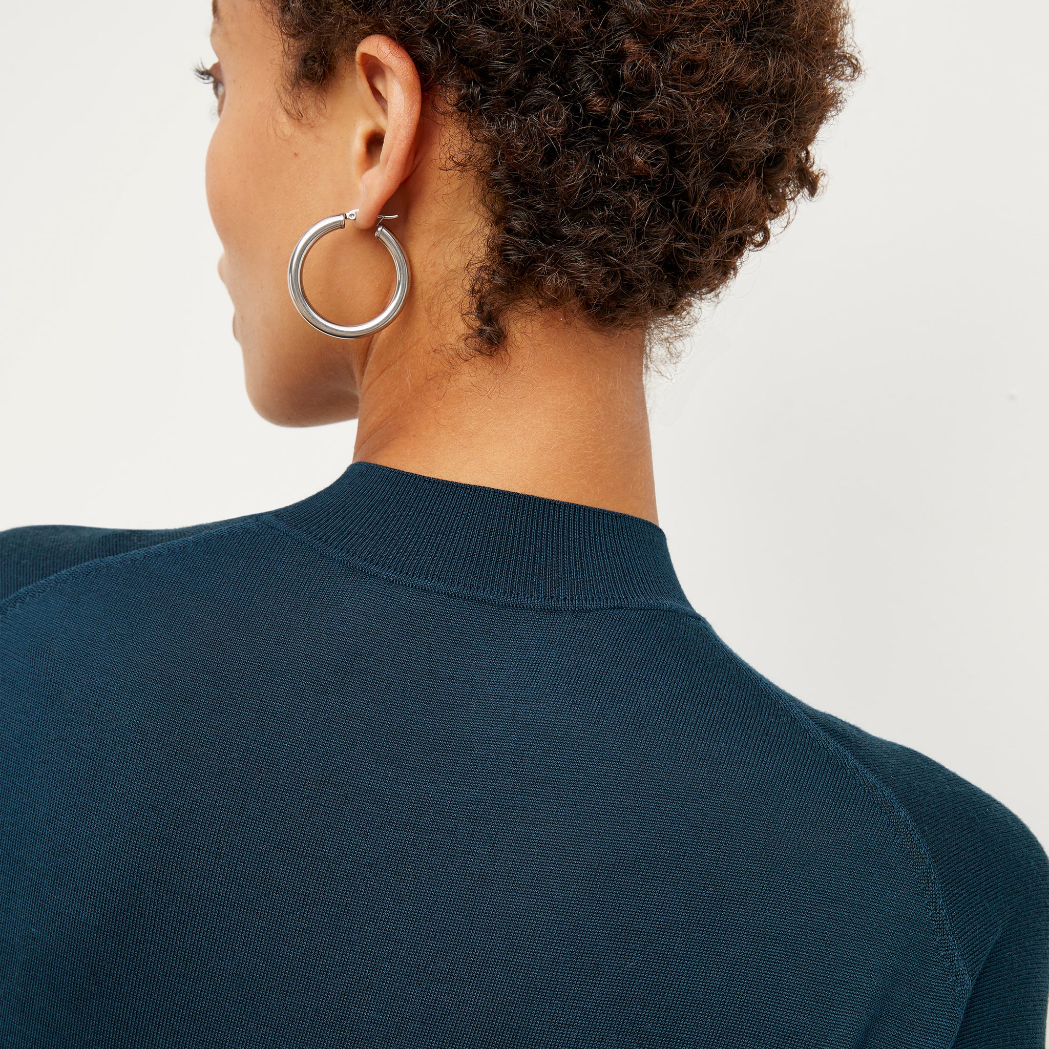 Detail image of a woman standing wearing the Claressa Earrrings Medium in Silver