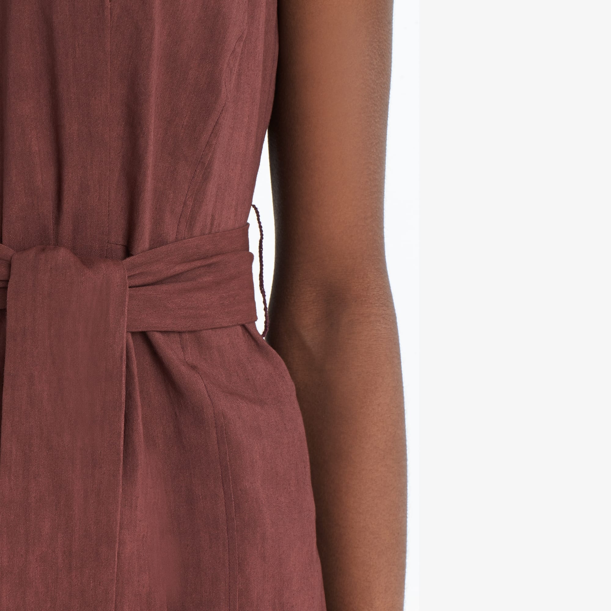 Detail image of a woman standing wearing the Angelina top stretch linen in sumac
