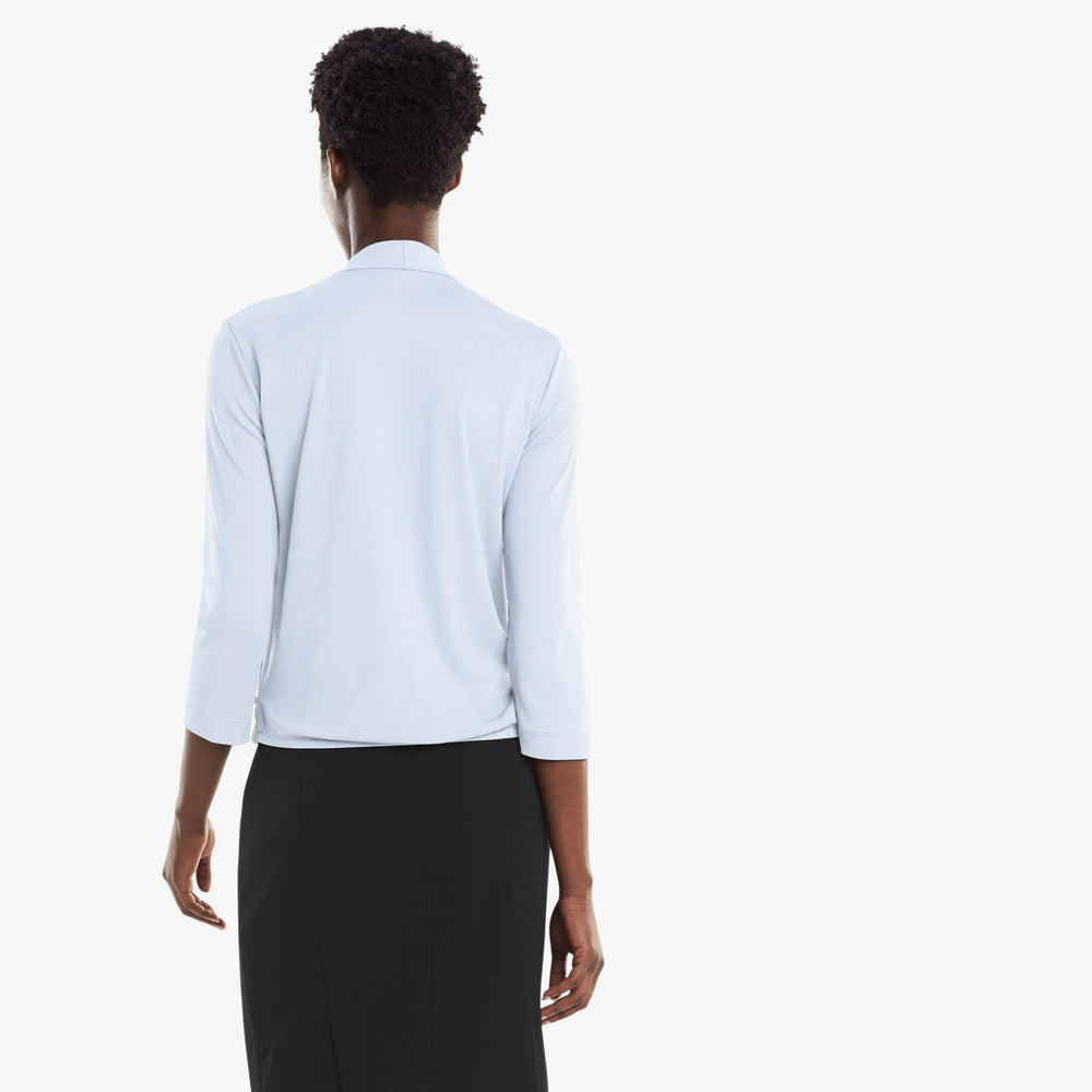 Back image of a woman standing wearing the Deneuve top in Oxford Blue