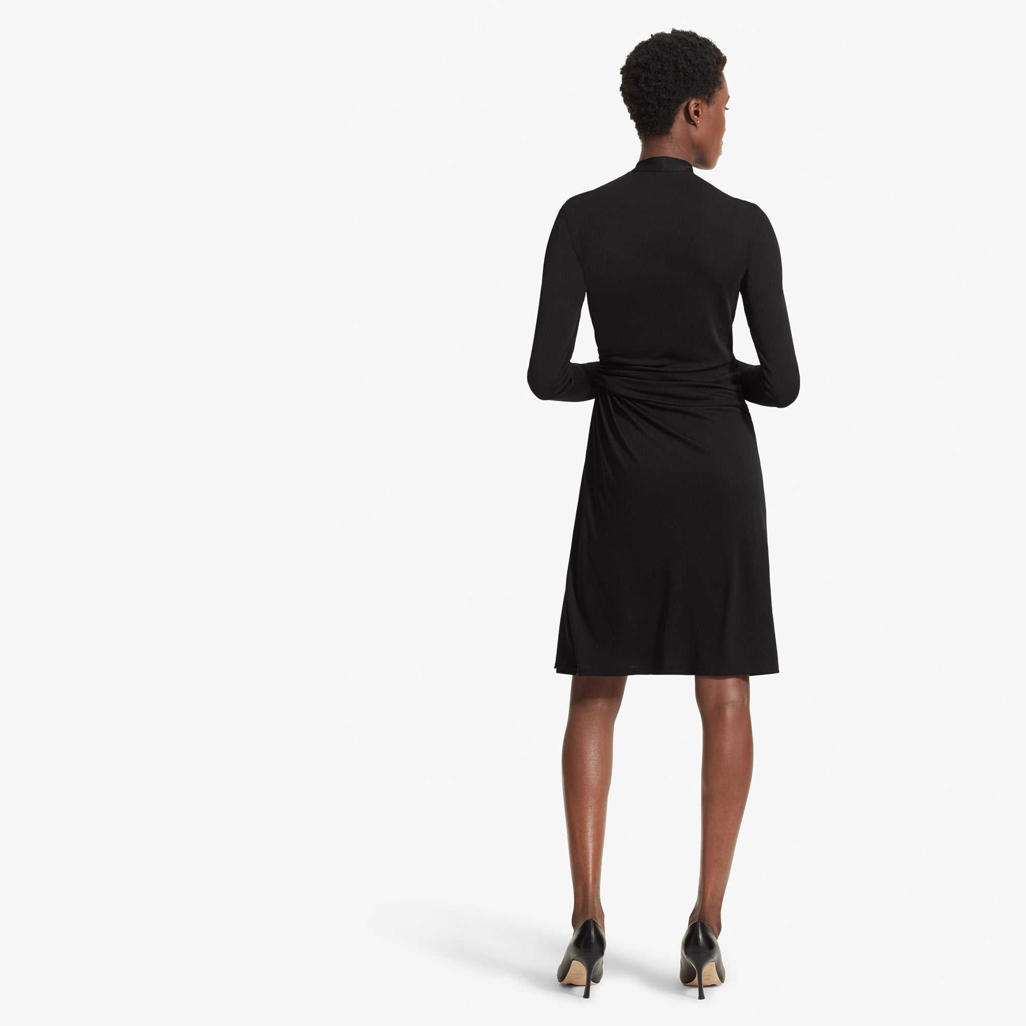 Back image of a woman standing wearing the Morgan dress in Black