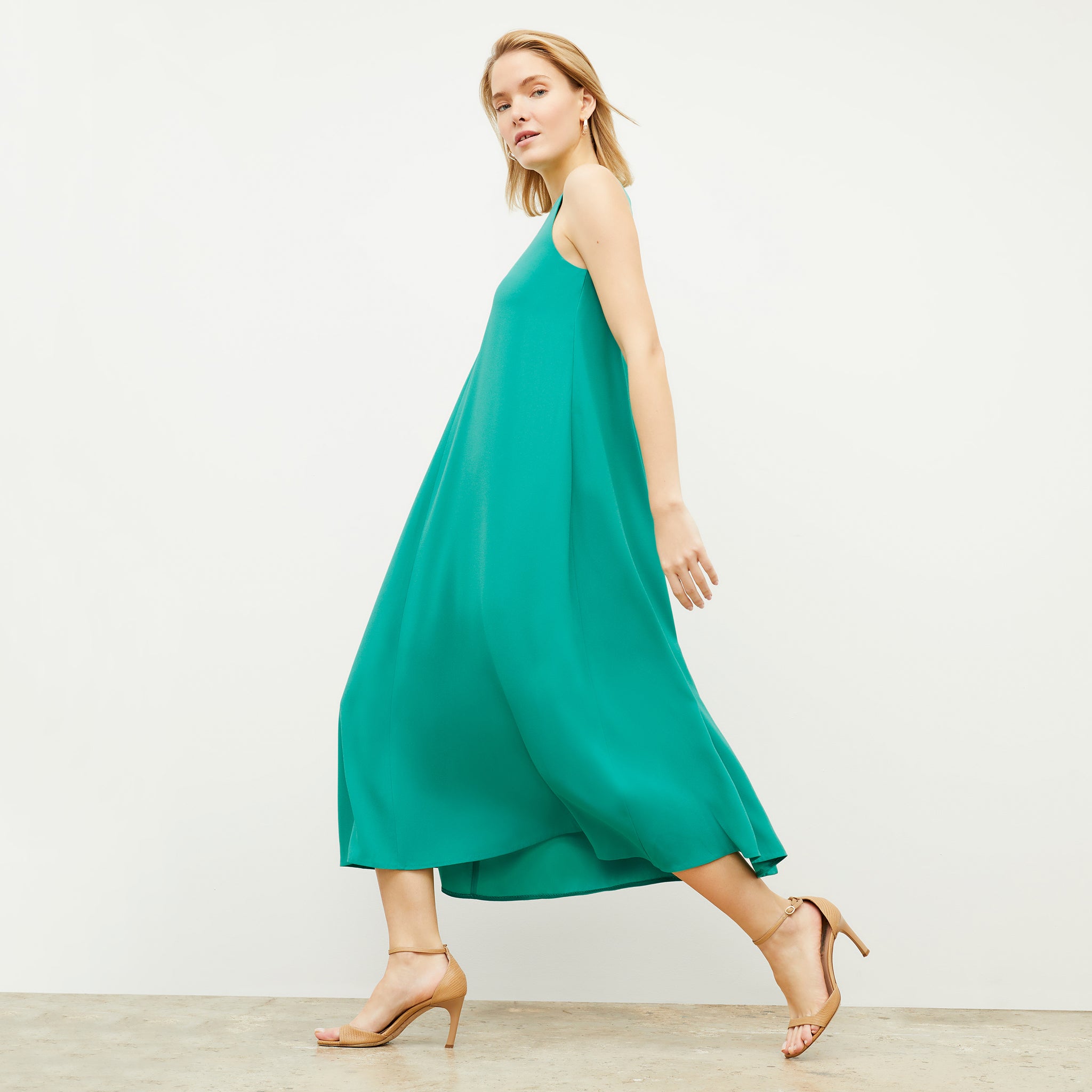 Side image of a woman wearing the Fatima Dress - Eco Heavy Crepe in Tropical Green