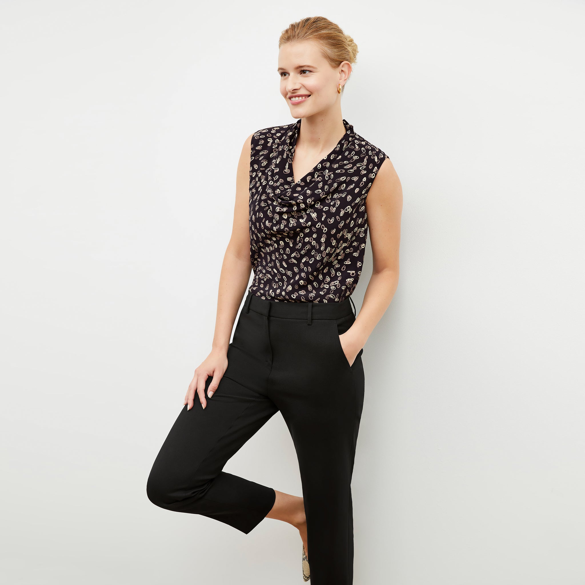 Front image of a woman wearing the Sloane top in spin dot 