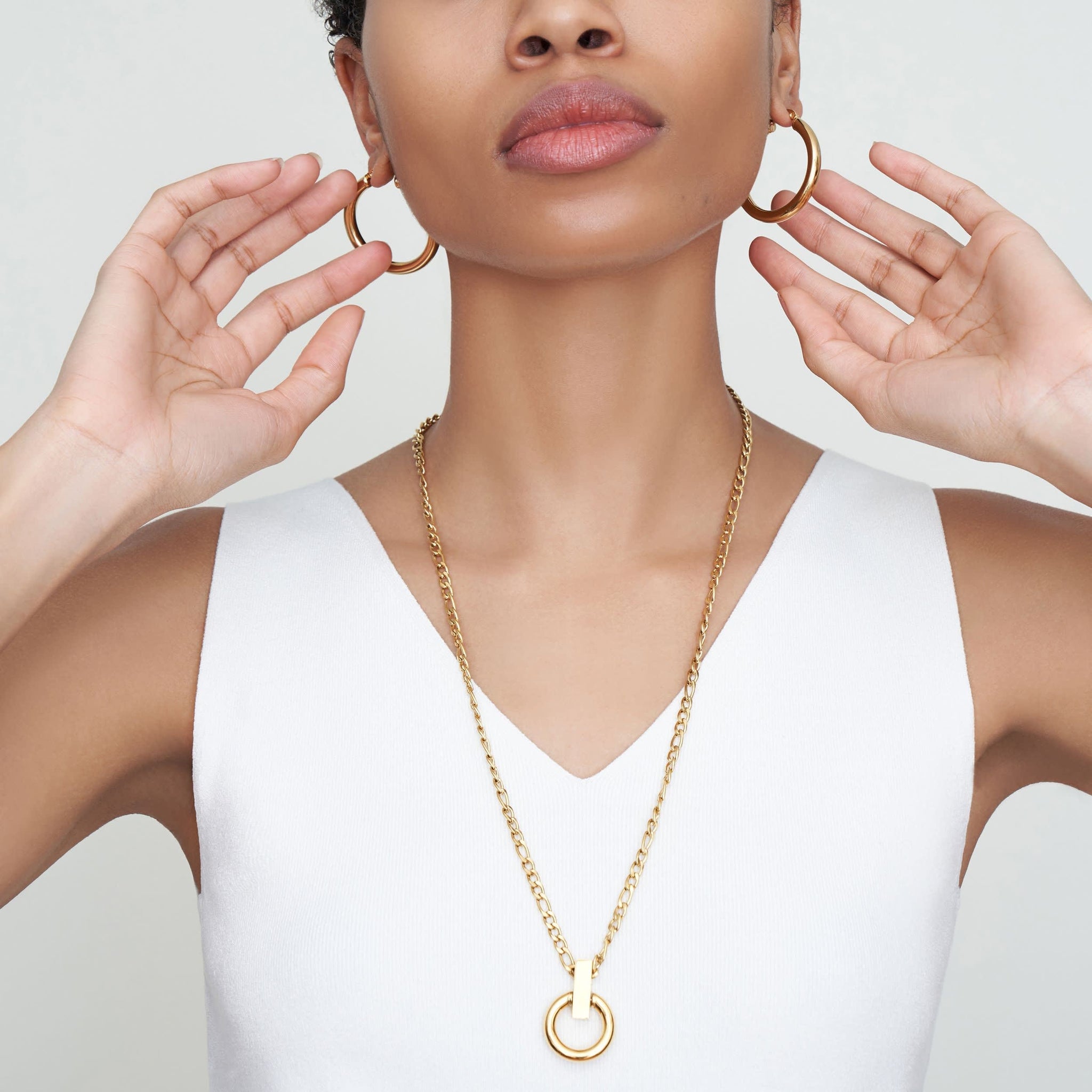 Detail image of a woman standing wearing the Claressa Earrings—Medium in Gold