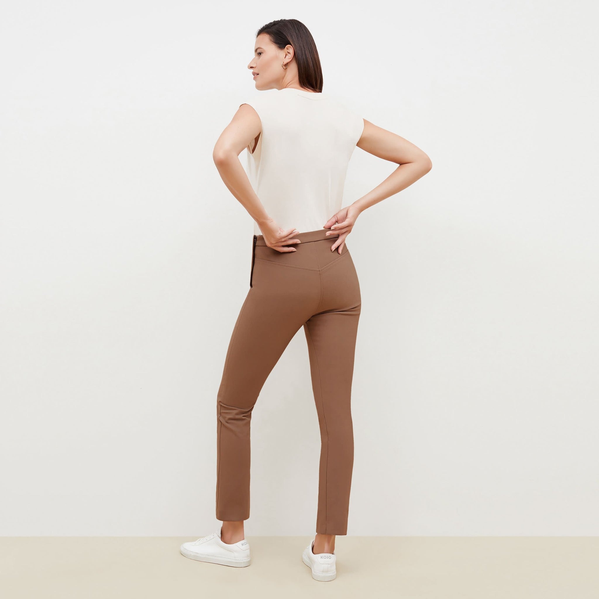 Back image of a woman standing wearing the Foster Pant—Everstretch in Saddle