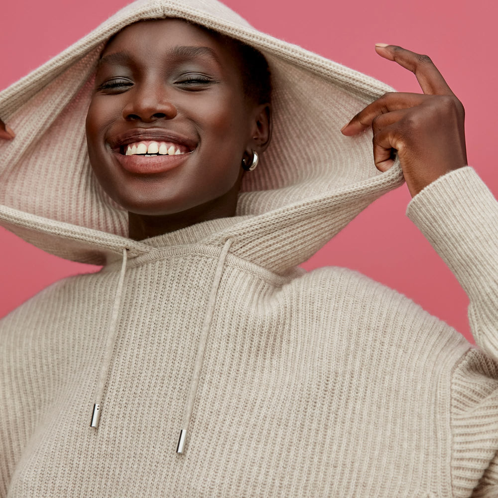 Front image of a woman standing wearing the Freya Hoodie—Cashmere/Wool in Oatmeal Melange