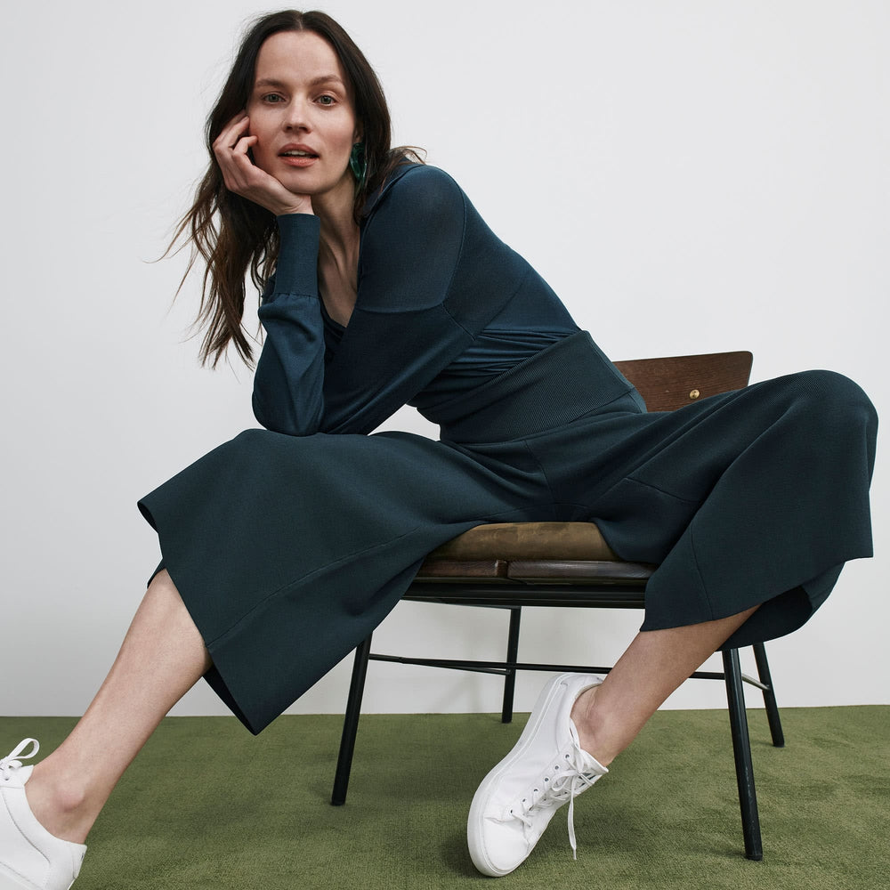 Side image of a woman standing wearing the leo top in deep sea