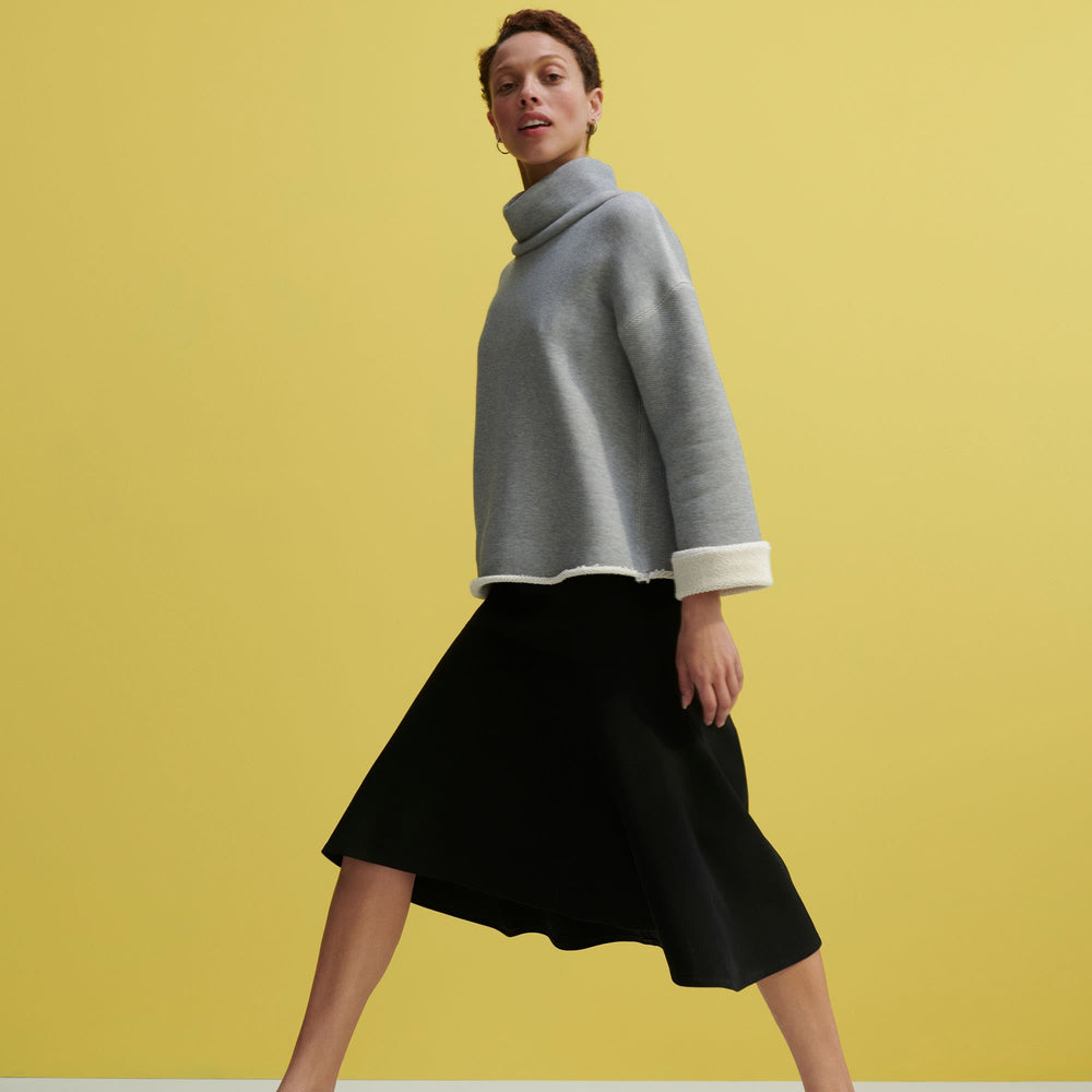 Side image of a woman standing wearing the Sharon Top—Plush Terry in Gray / Ivory