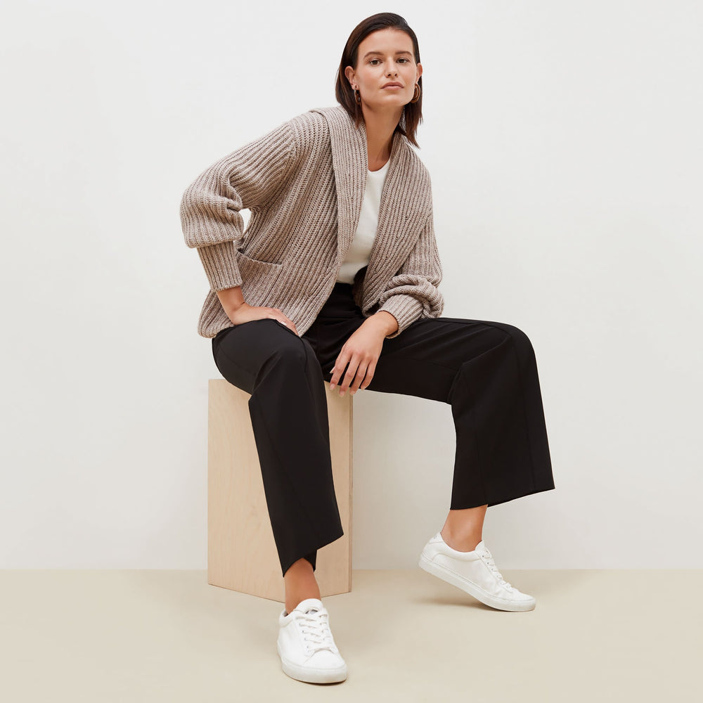 Front image of a woman sitting wearing the Snyder Jacket—Lush Merino in Barley