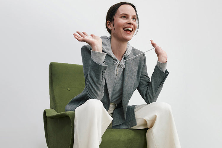 woman sitting in a green chair with her arms lifted