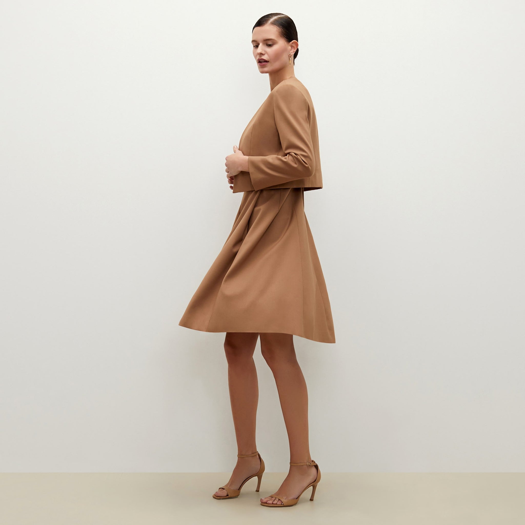 Side image of a woman standing wearing the Neale jacket in camel
