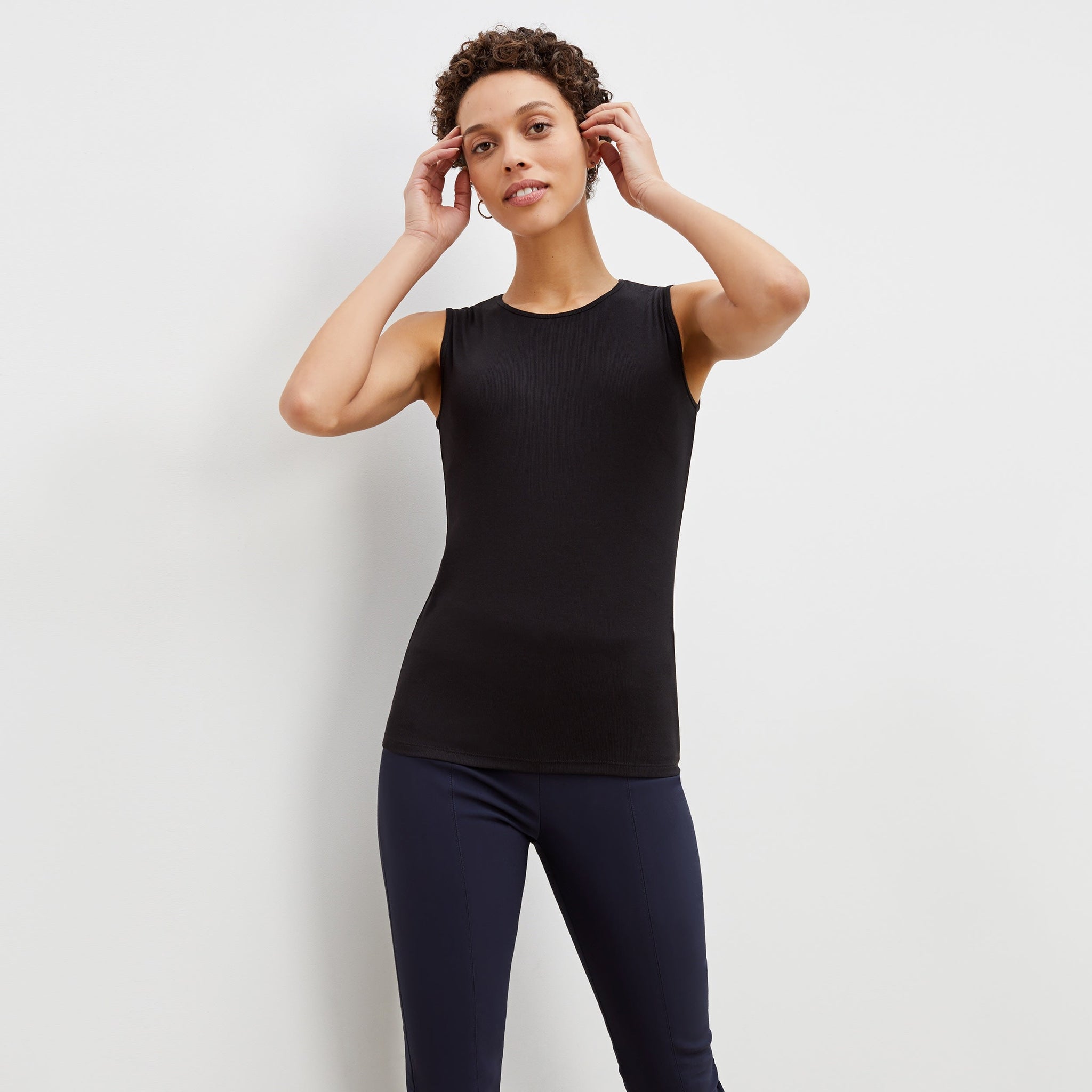 Front image of a woman standing wearing the paige top in fine ribbed cotton in black