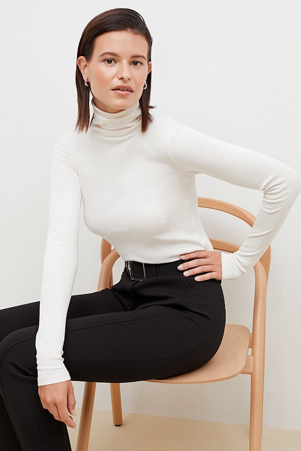 Front image of a woman standing wearing the axam top in ivory