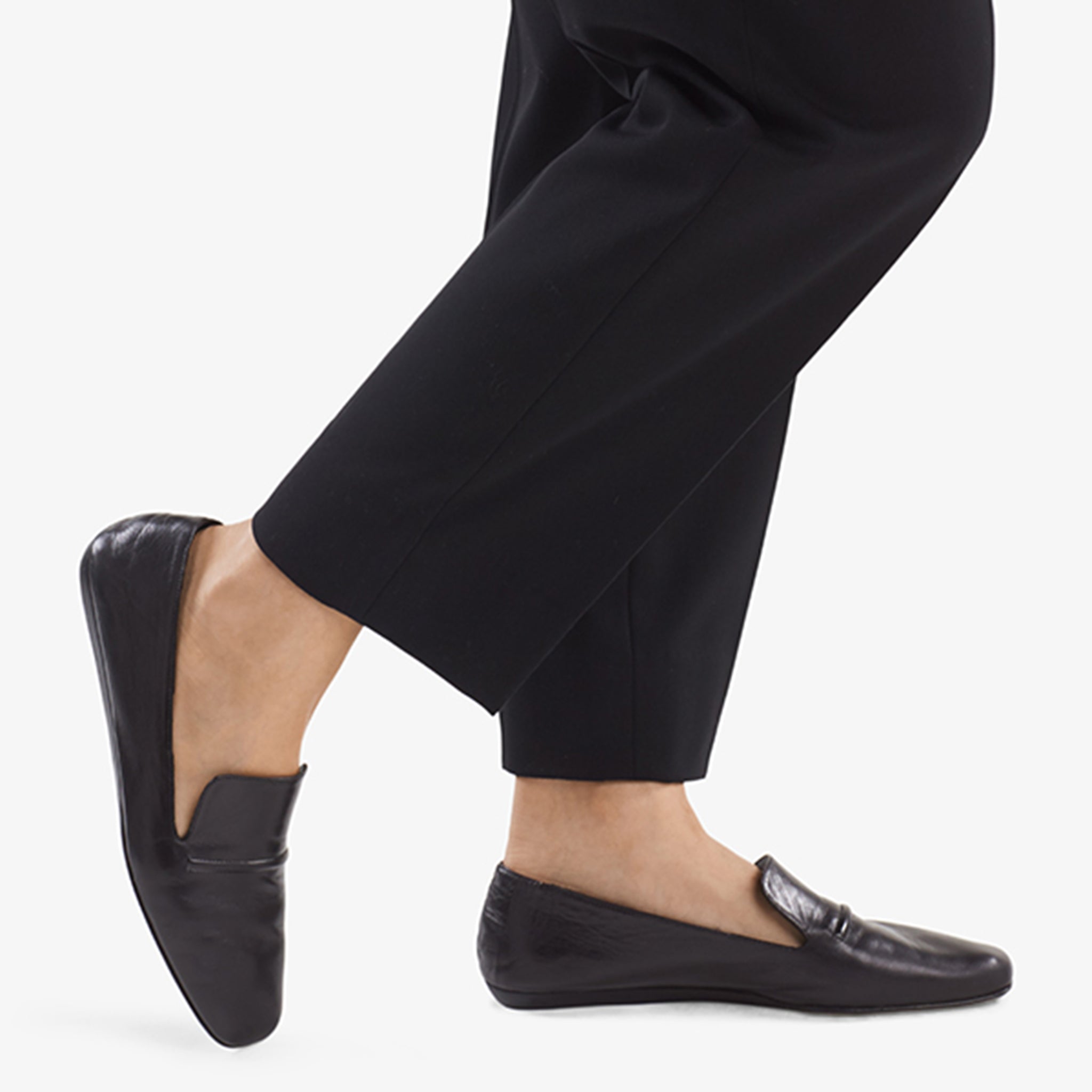 Side image of a woman standing wearing the Grace Loafer—Kidskin in Black