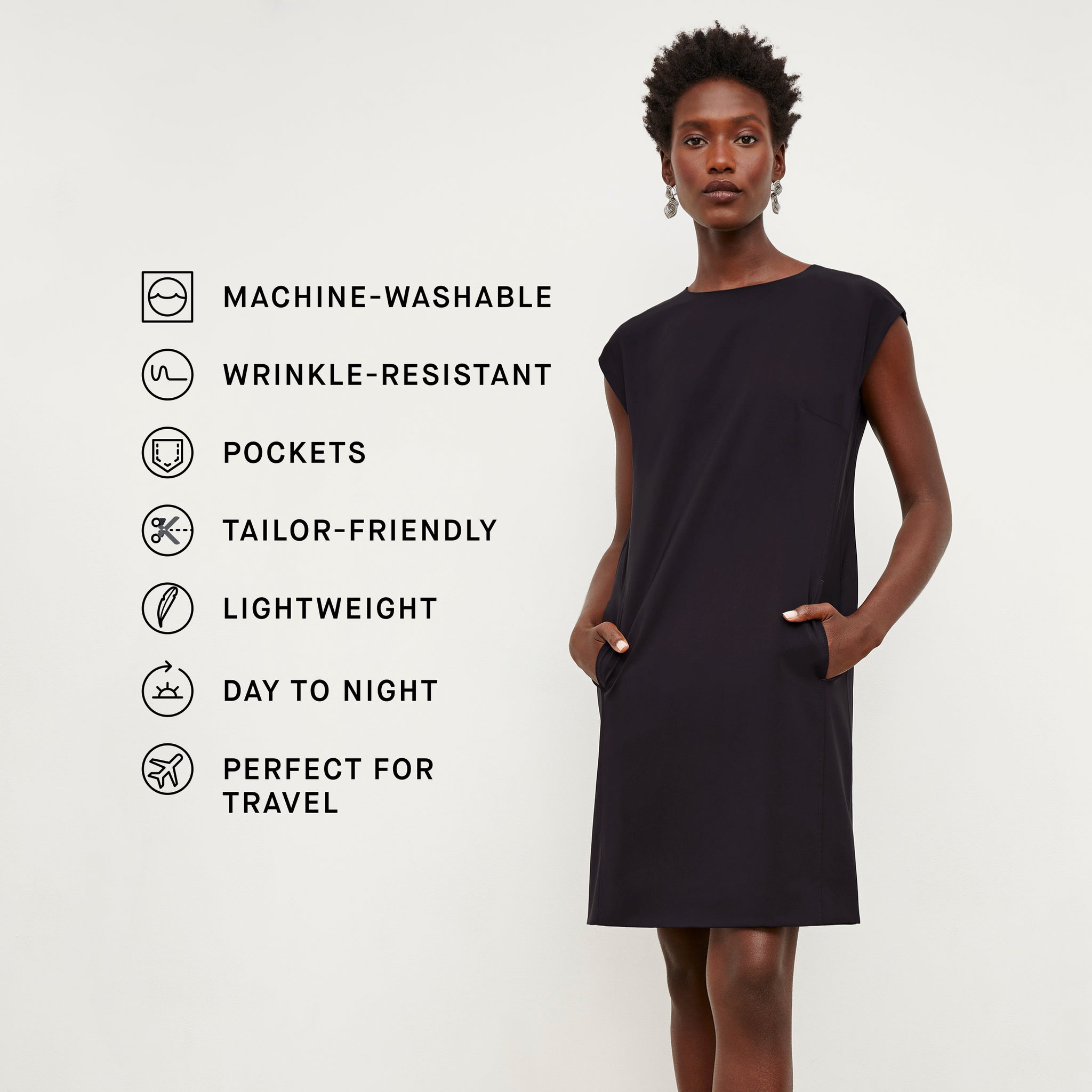 Front image of a woman standing wearing the Maaza Dress—Origami Suiting in Black with the product features listed
