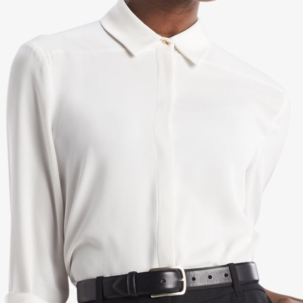 Cropped in image of a woman wearing an ivory button down