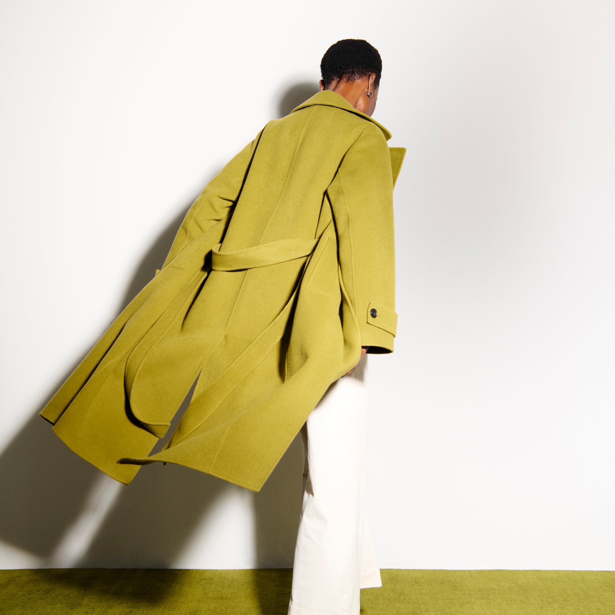 back image of a woman wearing the viola coat in pistachio