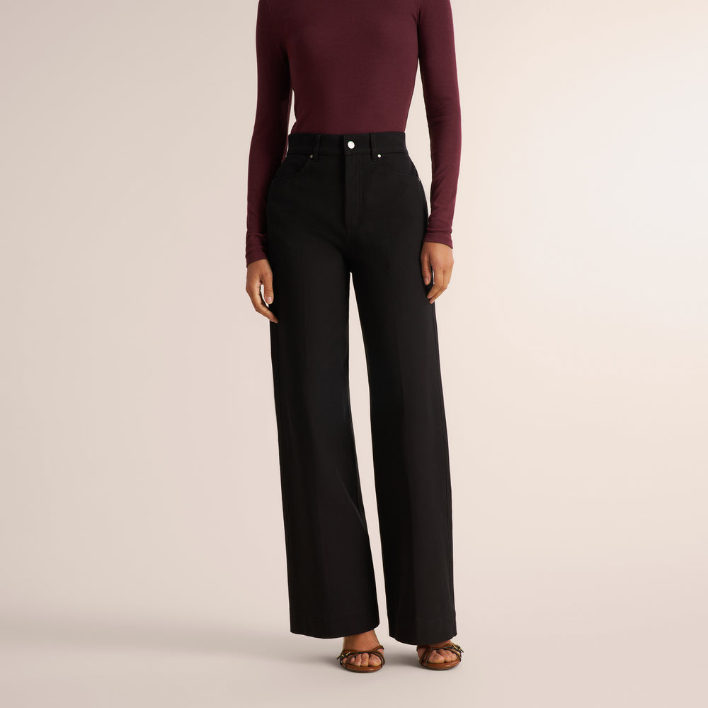 Woman wearing an aubergine long sleeve t-shirt with wide leg black jeans