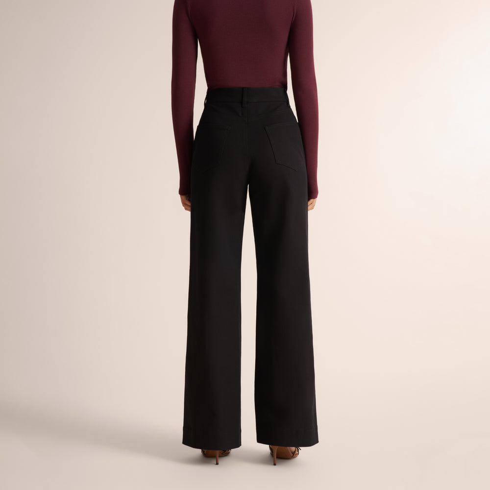 Woman wearing an aubergine long sleeve t-shirt with wide leg black jeans