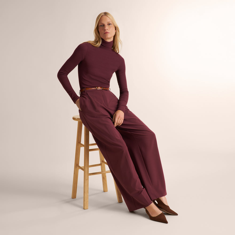 Woman wearing an aubgerine ribbed turtleneck with matching wide leg pants