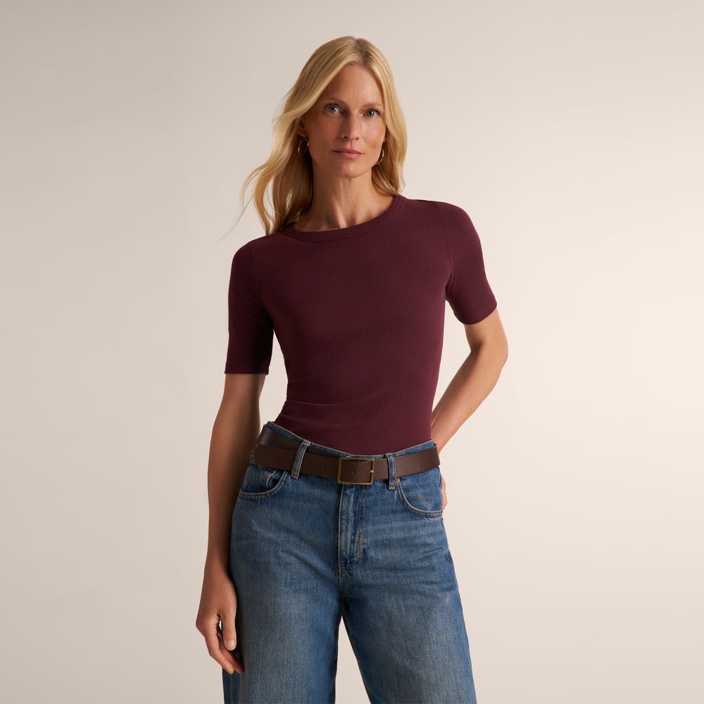 Woman wearing a short sleeve aubergine ribbed t-shirt with wide leg jeans