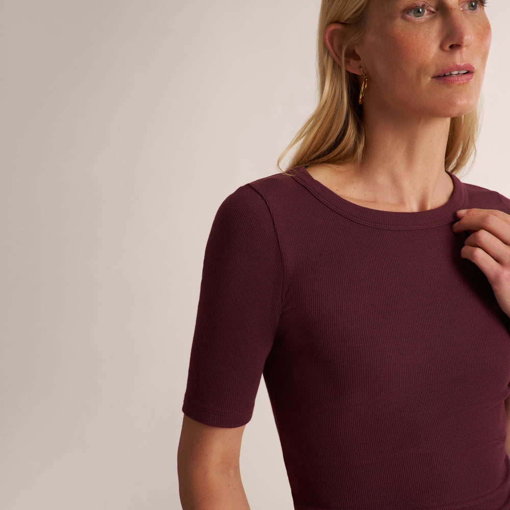 Woman wearing a short sleeve aubergine ribbed t-shirt with wide leg jeans