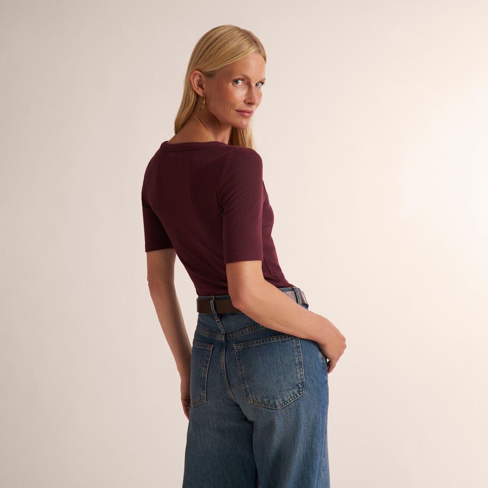 Woman wearing a short sleeve aubergine ribbed t-shirt with wide leg jeans