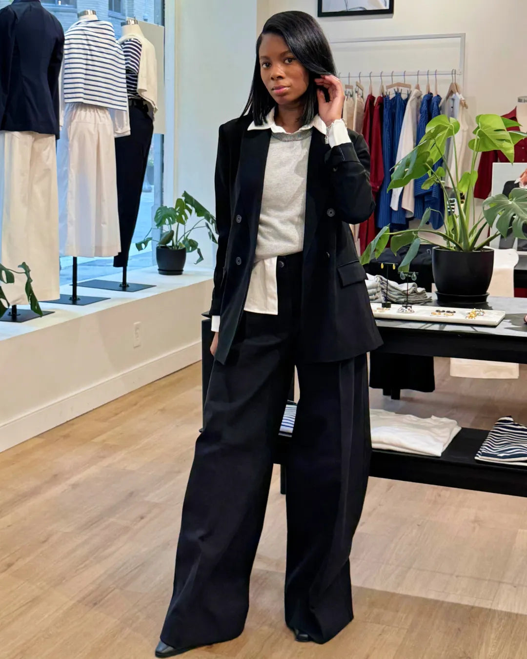 Person wearing a black suit in a clothing store setting