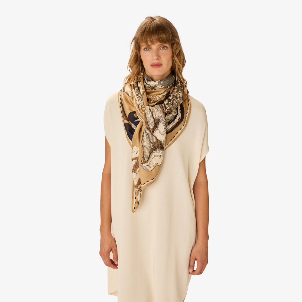 Woman wearing a beige scarf with a pattern on a white background