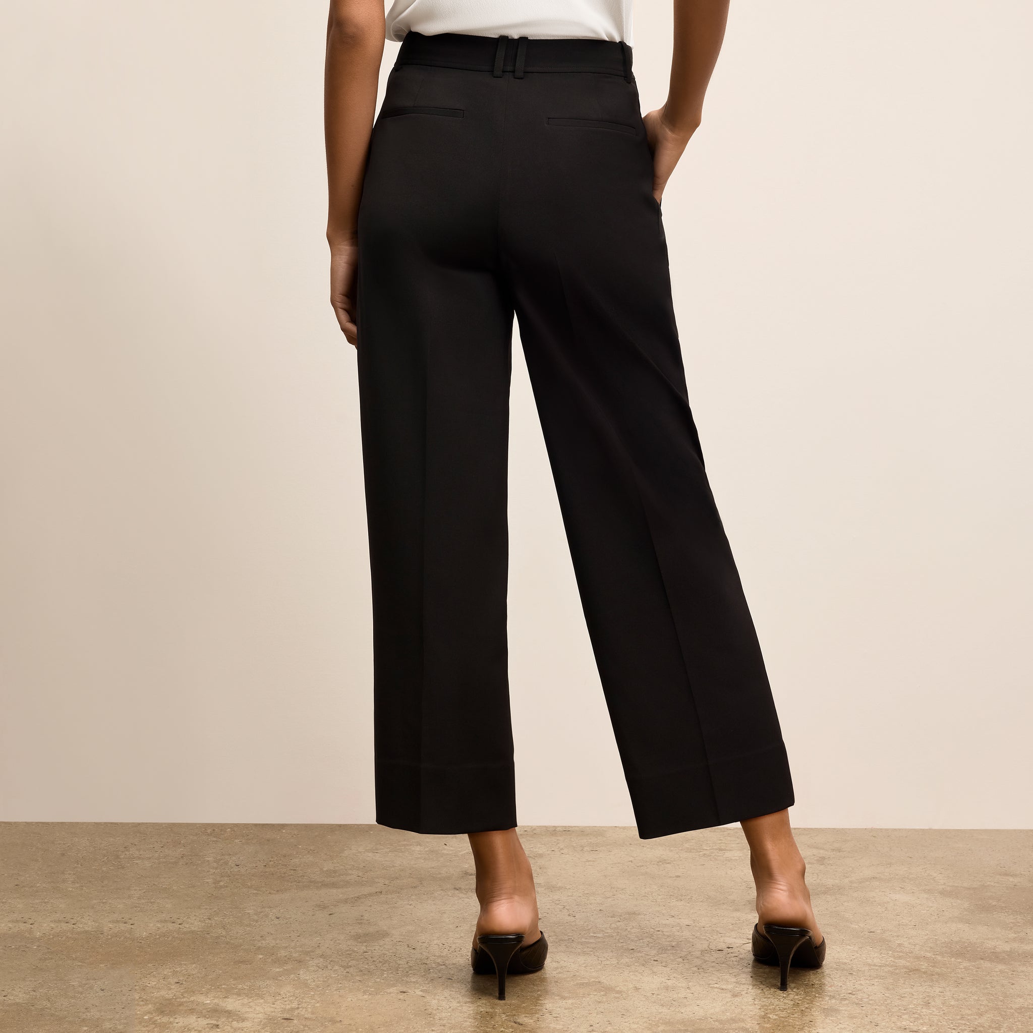 Person wearing black wide-leg pants against a plain background