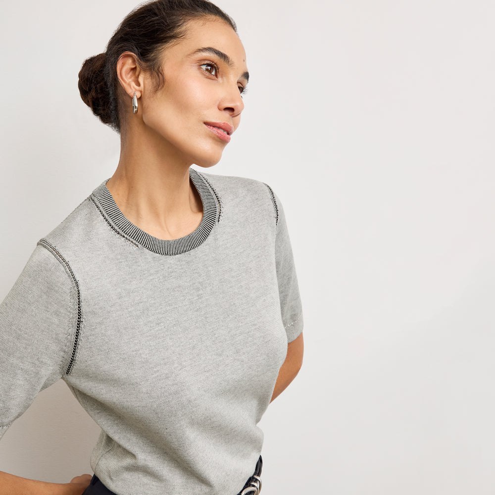 Front image of a woman wearing the becca top in light gray/ivory