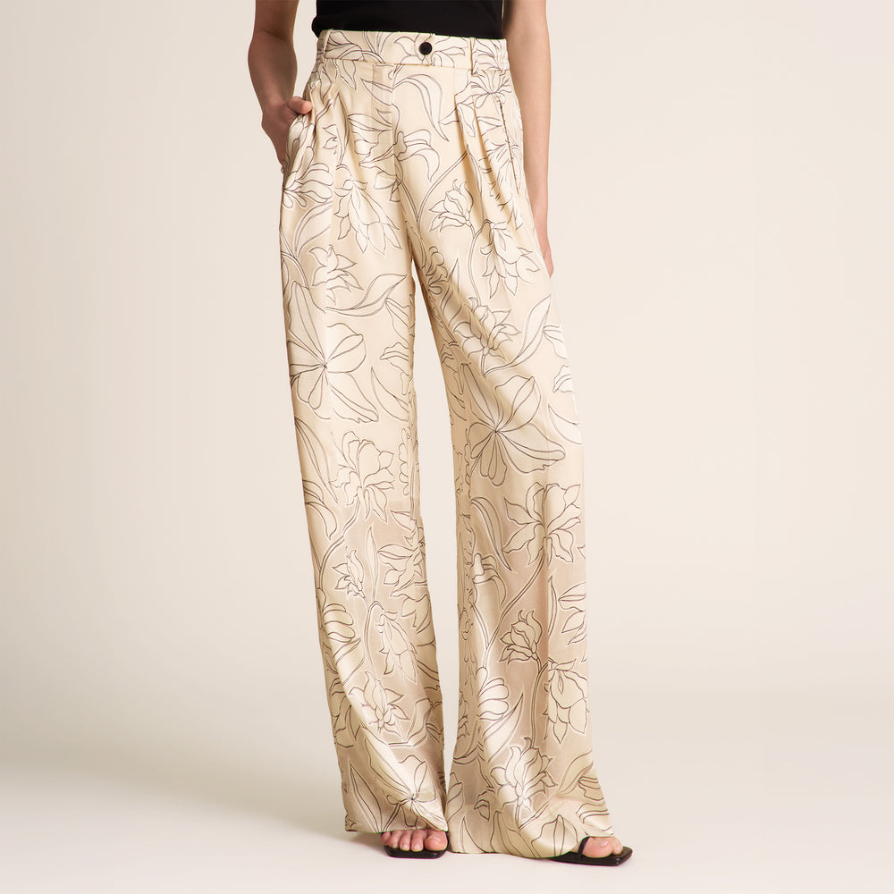 Beige floral-patterned pants worn by a person on a plain background