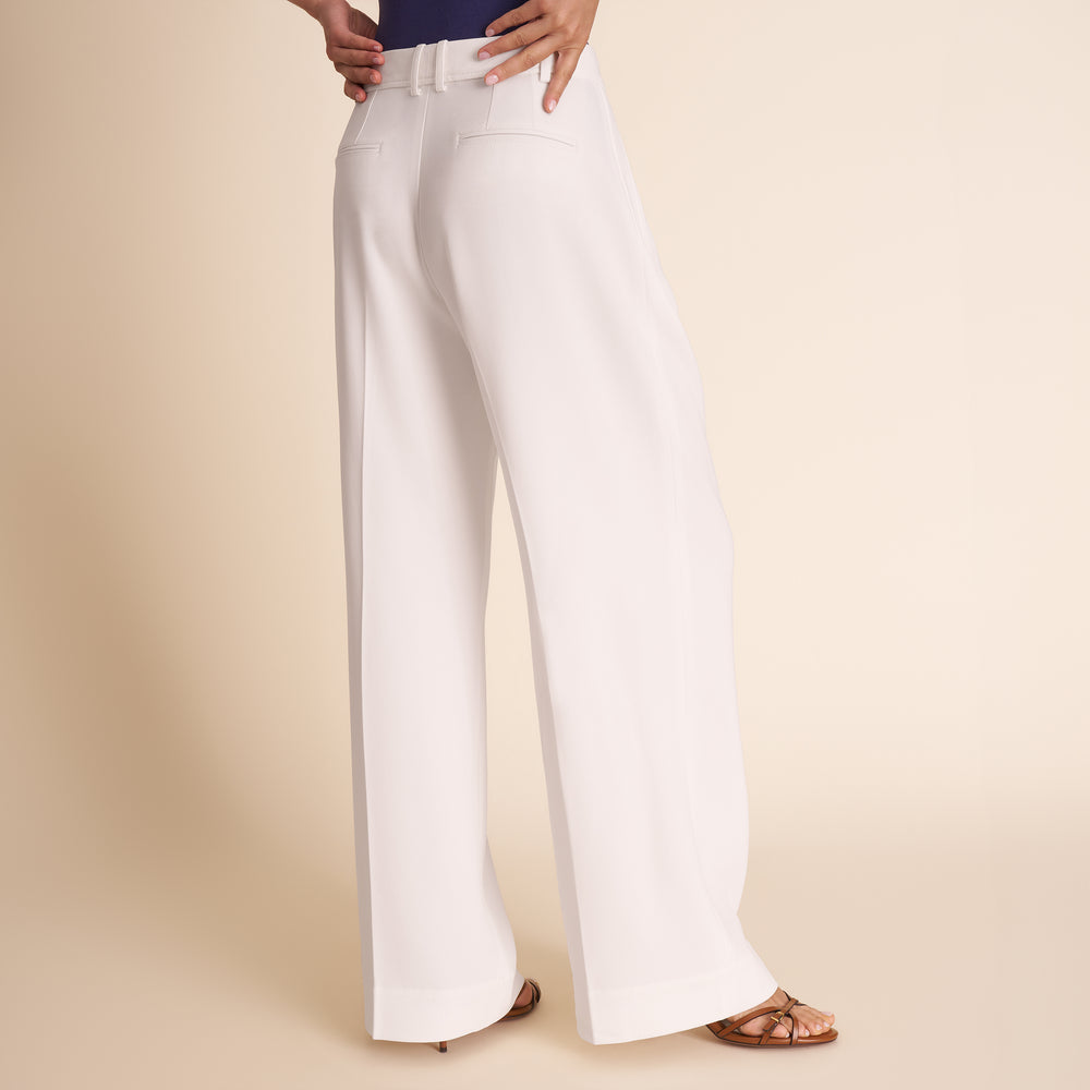 White pants worn by a person on a beige background