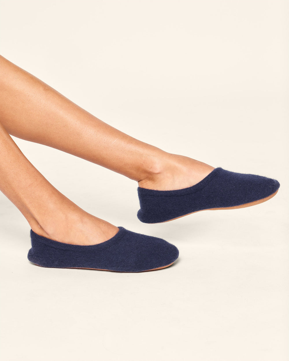 Navy blue slippers worn by a person on a light background